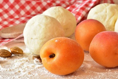 Frische Marillen und Marillenknödel-Zutaten auf einem Mehl bedeckten Tisch beim Alles Marille! Festival in Krems.